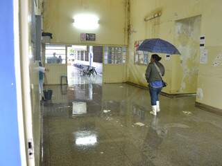 Por conta das goteira, mulher se protege com guarda-chuva dentro do posto de saúde. (Fotos: Minamar Júnior)