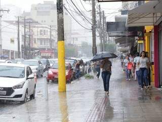 Consumidores buscaram fachadas de lojas para se proteger da chuva no Centro (Foto: Kísie Ainoã)
