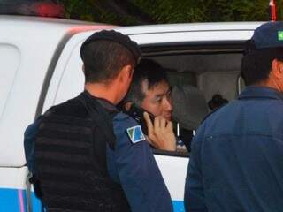 Policial rodoviário federal fala ao telefone dentro de viatura da PM depois de atira e matar empresário (Foto: Simão Nogueira)
