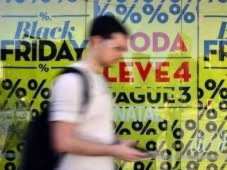 Rapaz caminha em área comercial e lojas anunciam promoções (Foto: Rovena Rosa/Arquivo/Agência Brasil)