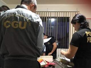 Policiais e agente da Controladoria Geral da União procuram por documentos na universidade (Foto: divulgação PF)