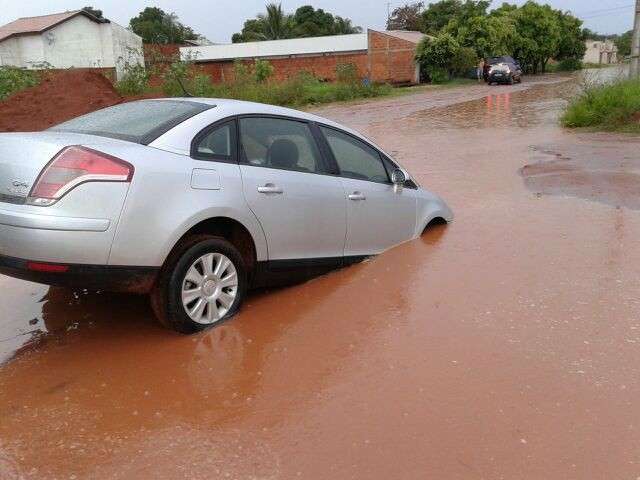 Popula&ccedil;&atilde;o sofre com ruas alagadas e carro &eacute; engolido por buraco