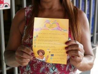 Dona do Bar da Tia, Lenir dos Santos Soares segurando panfleto criado por estudantes (Foto: Fernando Antunes)