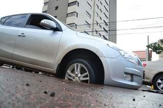 Carro cai em buraco no Centro de Campo Grande, motorista n&atilde;o ficou ferido