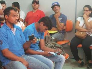 Wesley de Souza Batista, ao lado do pai, observa a Carteira de Trabalho que havia acabado de receber das mãos do prefeito Bernal (Foto: Antonio Marques)