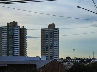 Céu parcialmente nublado em meio a prédios, em Campo Grande; dia amanheceu quente (Foto: Marina Pacheco)