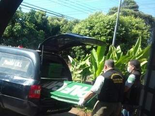 Agentes funerários colocam corpo dentro de carro. Cadáver será encaminhado ao Imol  (Foto: Rafael Ribeiro) 