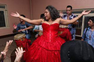 Vestida de vermelho, a entidade Maria Mulambo entrou no corpo da médium Aline Arcanjo (Foto: Henrique Kawaminami)