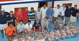 Há dez anos, os 18 colegas entregam cestas básicas às famílias que vivem as margens do Rio Paraguai (Foto: Diário Corumbaense)