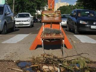 Cadeira sinaliza buraco junto a quebra-molas na Rua Dom Aquino, Bairro Amambaí. (Foto: Alcides Neto)