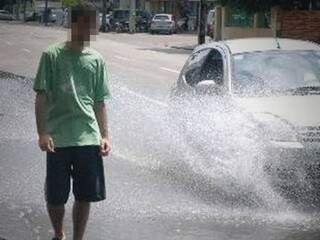 Carro espirra água e molha pedestre em foto divulgada pelo Detran-MS (Foto: Detran-MS/Divulgação)