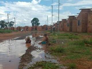 No Pedro Teruel, crianças moravam na Cidade de Deus brincam em poça d&#039;água em frente a casas inacabadas (Foto: Simão Nogueira)