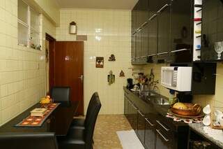 Cozinha mantida original, parede de azulejos, piso de mármore e armários planejados (Foto: Kísie Ainoã)