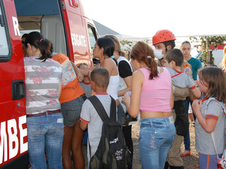 Alunos e parentes de crianças que passaram mal em escola se aglomeram próximo de viatura dos bombeiros. (Foto:Simão Nogueira)