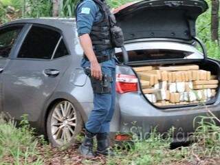 Policial militar ao lado do veículo carregado com a droga. (Foto: Sidrolândia News) 