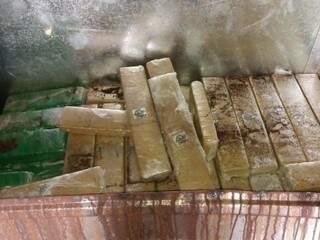 Tabletes de droga encontrados sob a lataria do veículo. (Foto: Porã News) 
