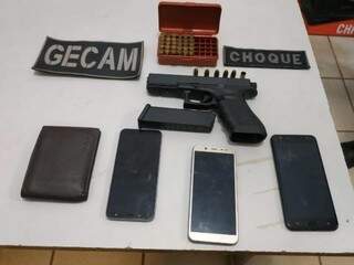 Pistola, carteira e celulares foram apreendidos com os suspeitos 