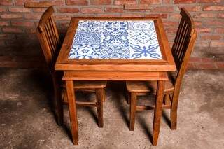 Mesa com cerâmica azul e branca no tampo, com duas cadeiras, antes custava R$ 1.590,00 e agora sai por apenas R$ 954,00.