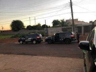 Policiais em frente à casa de um dos suspeitos. (Foto: Divulgação/Polícia Civil)