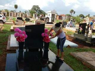 Cláudia coloca flores no túmulo do avô, no cemitério Santo Amaro, que faleceu há 20 anos (Foto: Christiane Reis)