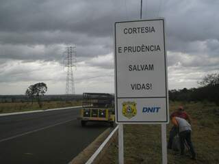 Operários do Dnit instalam placa em margem de rodovia. (Foto: Divulgação/PRF)
