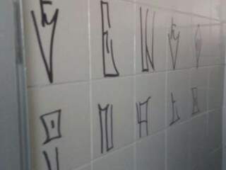Pichação feita nos azulejos da parede dos sanitários. (Foto: Direto das Ruas) 