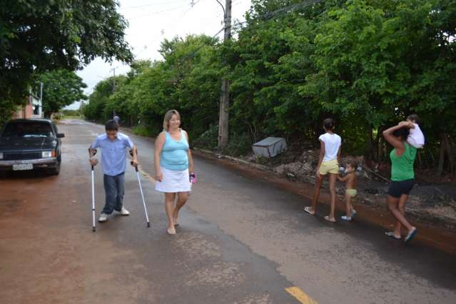 Com cal&ccedil;adas ocupadas pelo lixo e mato, morador anda no meio da rua
