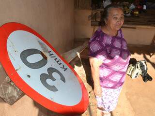 Maria de Lourdes Rodrigues, de 70 anos, guarda uma placa de trânsito na varanda de casa. (Foto: Minamar Junior)