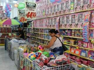 Mulher observa brinquedo em loja na região central de Campo Grande (Foto: Paulo Francis)