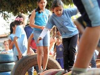 Crianças de escola municipal brincam com pneus adaptados para a diversão. (Foto: Divulgação/PMCG)