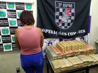 Jovem ao lado dos tabletes da droga que ela entregaria em Londrina. (Foto: Adilson Domingos) 