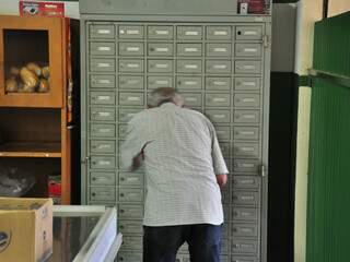 Fidelcino de Souza pega correspondência na Caixa Postal dos Correios aberta na conveniência da Cleuza. (Fotos: João Garrigó)