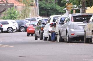 Esperando o próximo &quot;cliente&quot; José se camufla em meio aos carros. (Foto: Alcides neto)