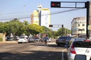 Carro não respeita sinal vermelho e pedestre faz a travessia mesmo sem faixa. (Foto: Fernando Antunes)