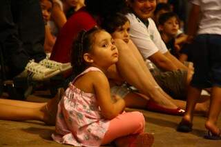 Eduarda, de 3 anos, só tinha olhos para a alegria dos bonecos no palco. 