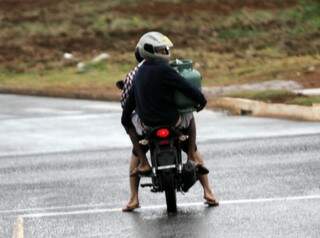 Em meio à falta do produto, cliente transporta botijão de gás em motocicleta(Foto: Saul Schramm)
