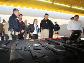 Superintendente da PRF, Luiz Alexandre Gomes, mostra as armas que serão utilizadas ao presidente da OAB-MS, Mansour Elias Karmouche (Foto: Gerson Walber/OAB-MS)