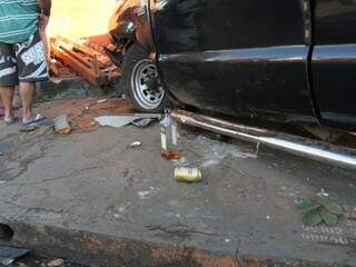 Garrafa de wisk e lata de cerveja ao lado do veículo. (Foto: Saul Schramm).