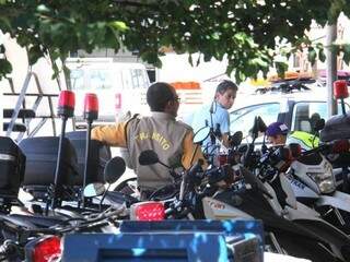 Agente de trânsito ao lado de diversas motos paradas no pátio da Agetran na tarde de sexta=-feira (15). (Foto: Alan Nantes)