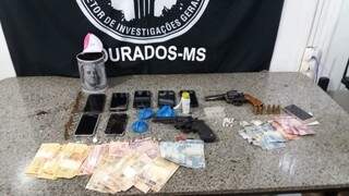 Armas usadas na troca de tiros, dinheiro, celulares e pacotes de drogas apreendidos hoje (Foto: Divulgação)