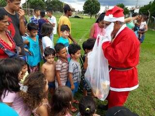 Papai Noel distribuindo os presentes para as crianças. (Foto: Divulgação) 