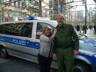 Em Frankfurt, na Alemanha, delegada pede para fotografar policial ao lado de viatura. 