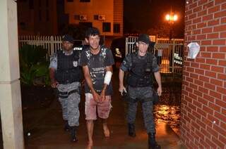 Com a roupa suja de sangue, Wagner de Souza é conduzido por policiais militares (Foto: Sidney Bronka/94 FM)