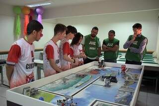 Juízes analisam trabalho de alunos que participam do torneio de robótica (Foto: Divulgação)