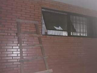 Escada apoiada em parede nos fundos da agência - ao lado de janela que teve vidro e grade quebrada (Foto: Idest) 