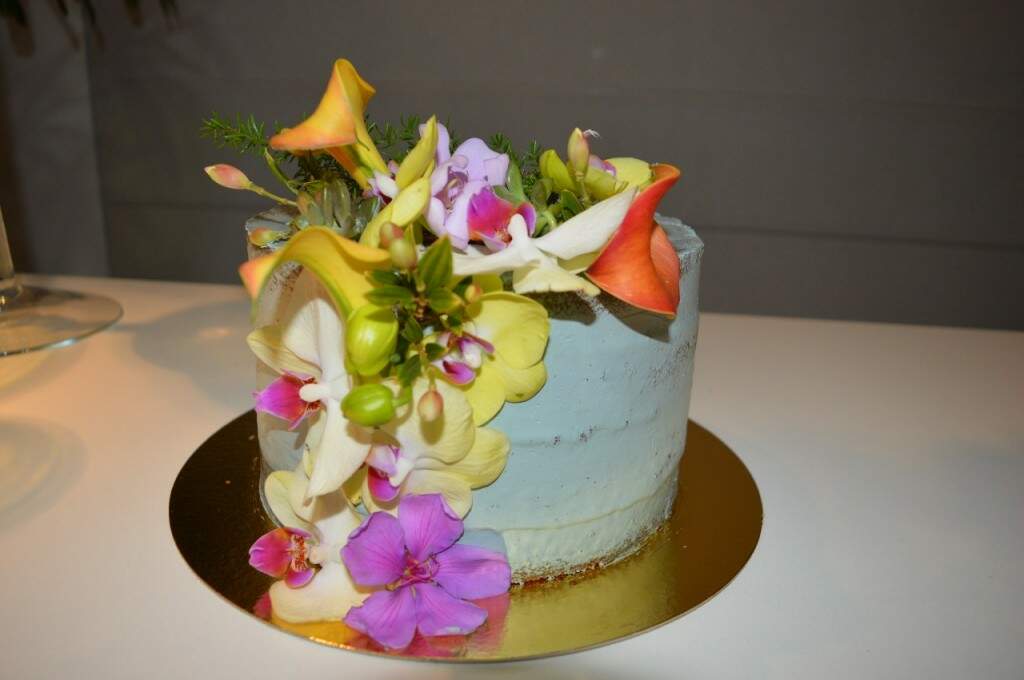 Feminino mão decorando o bolo de aniversário de casamento flor
