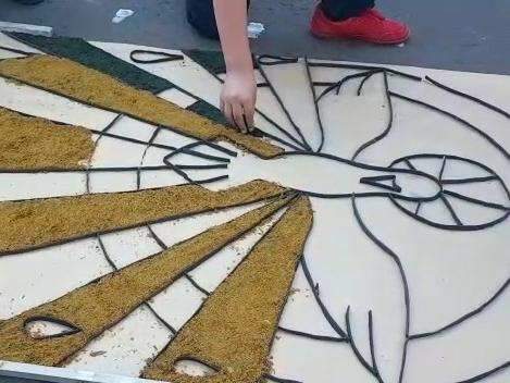 Serragem, tampinhas de garrafa e areia pintam asfalto na 14 de Julho