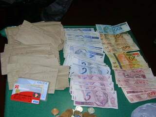 Foto mostra dinheiro e cartões apreendidos com comerciante. (Foto: Divulgação)