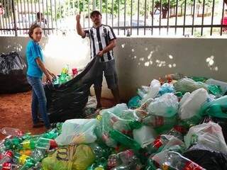 Voluntários ensacando as garrafas arrecadadas na Escola Wilson Taveira Rosalino, no bairro Aero Rancho (Foto: Operário/Divulgação)