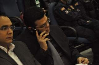 Prefeito fala ao celular durante audiência na Câmara (Foto: Marcelo Calazans)